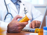 Doctor holding a container of pills