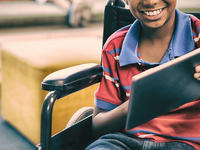 Paraplegic child using a tablet